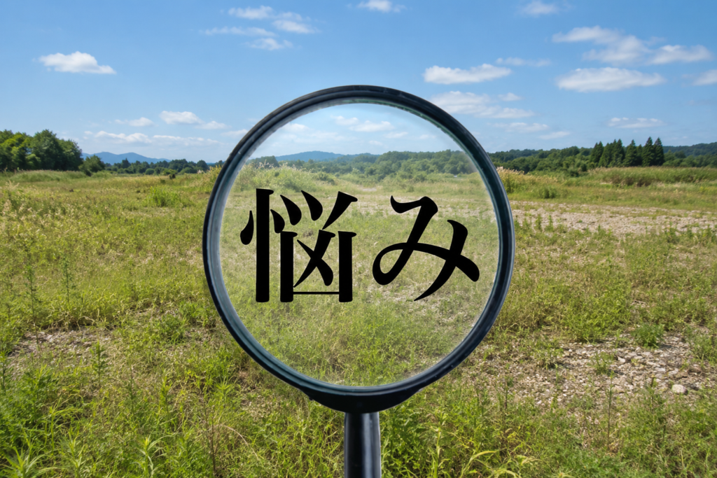 原野を背景に、虫眼鏡の中に「悩み」の文字を表示し、土地に関する悩みをイメージしたアイキャッチ画像